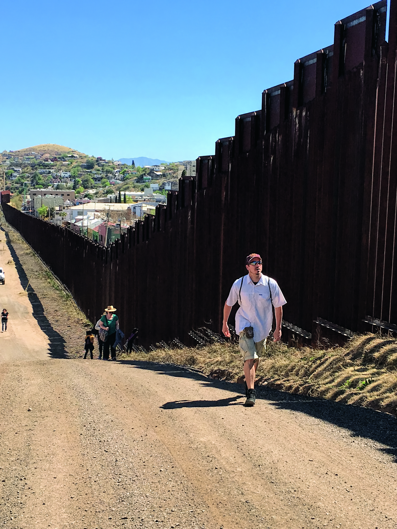 Students walking along the border wall in Nogales, Arizona