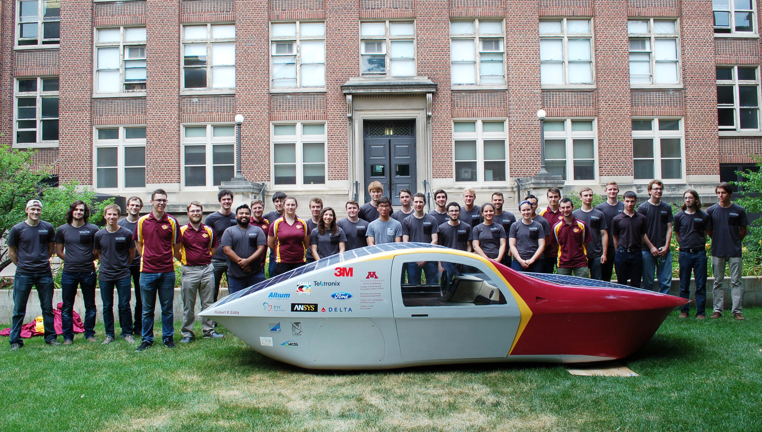 Photo of students standing with the solar-electric car
