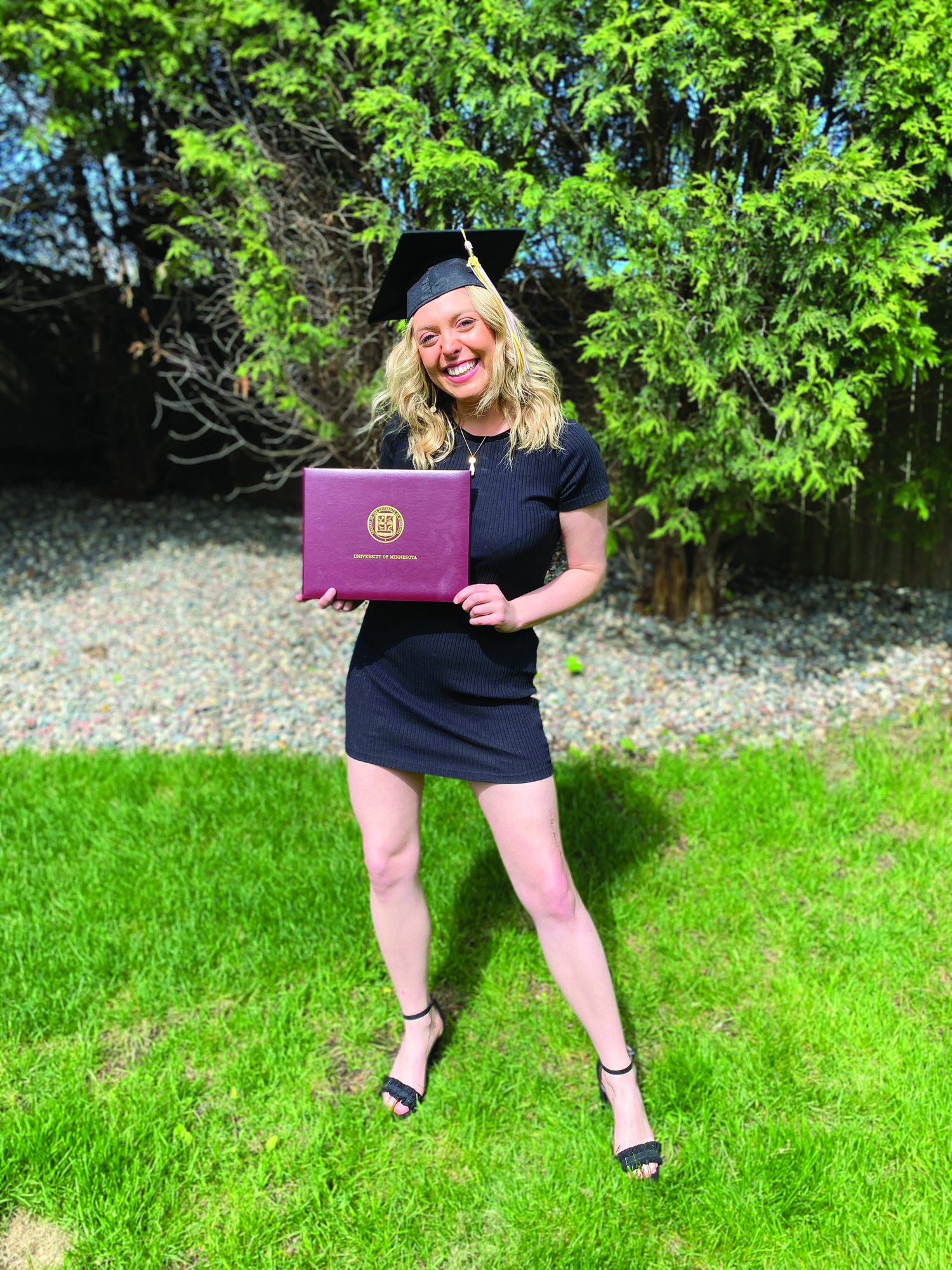 Girl wearing graduation cap holding diploma