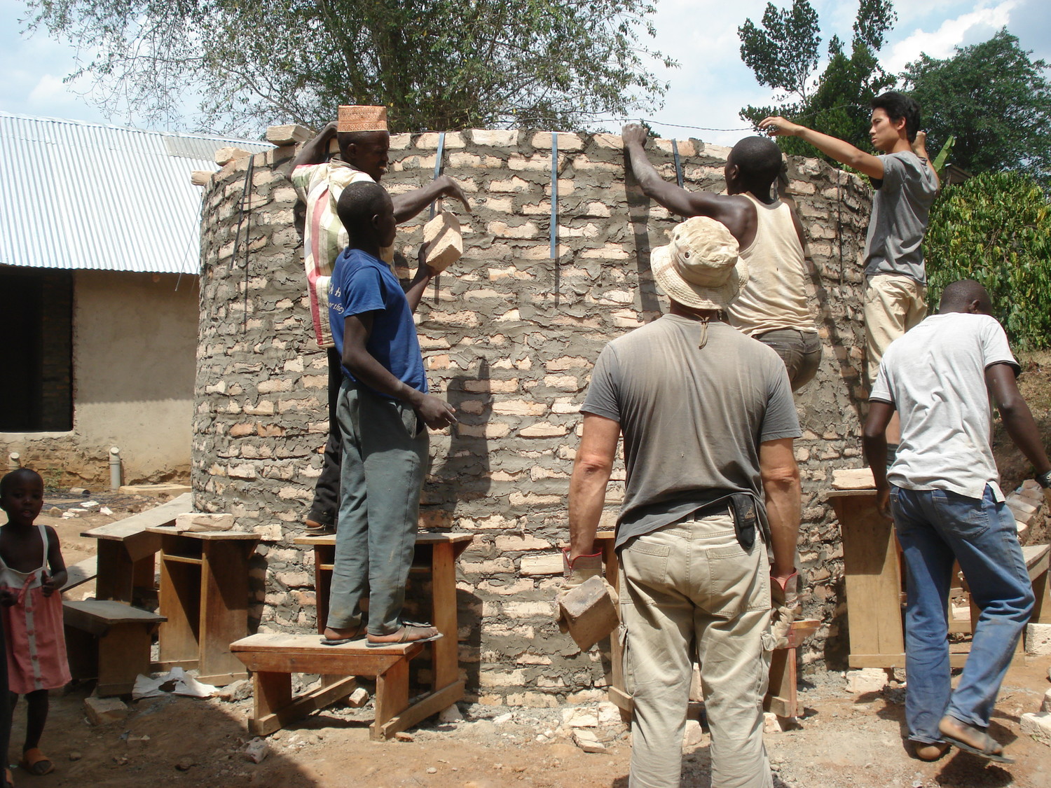 Photo of students and residents of Kyetume, Uganda, building a rainwater storage tank